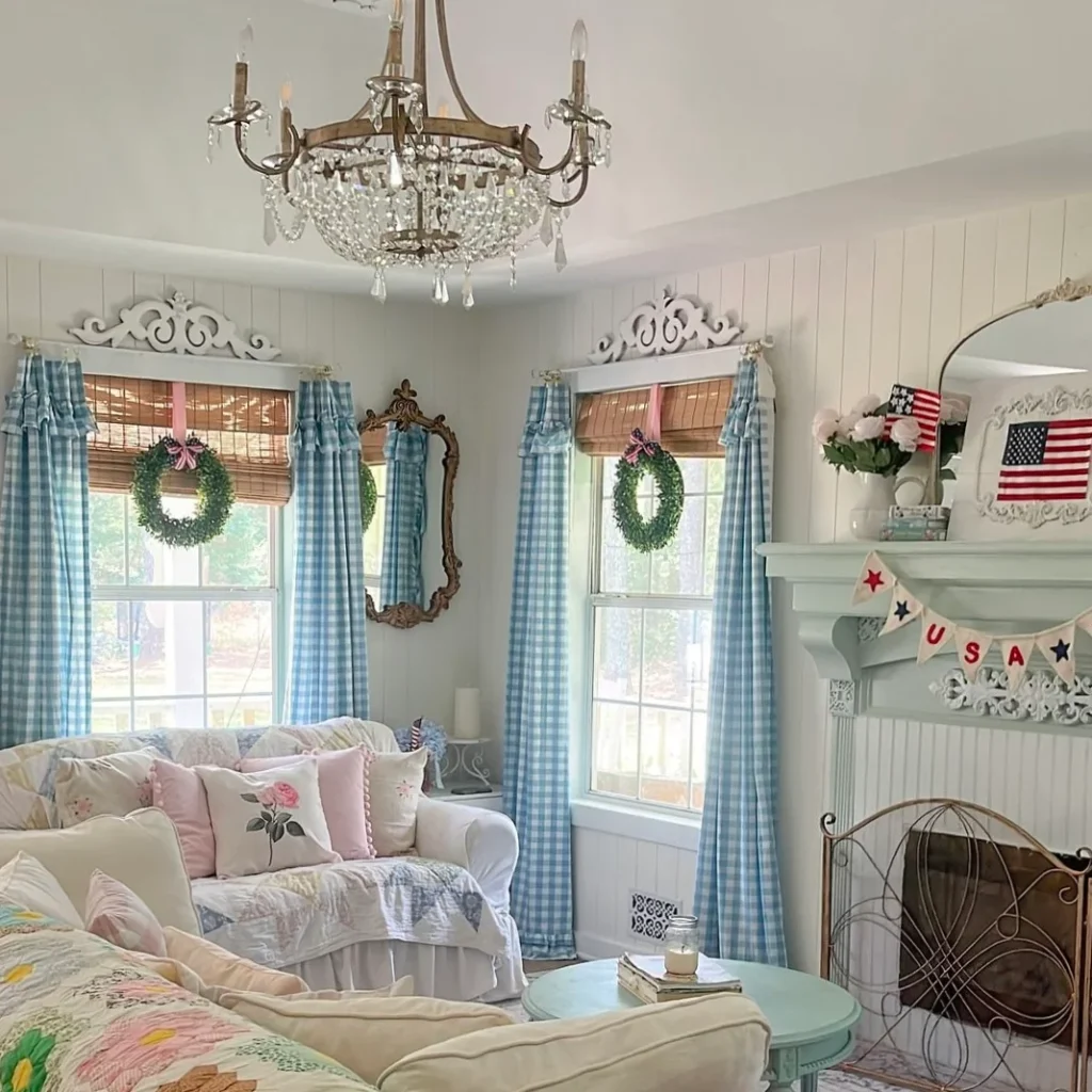 A granny chic living room with a cozy color scheme is shown. Blue and white checked curtains hang on open windows and have a grass bow.