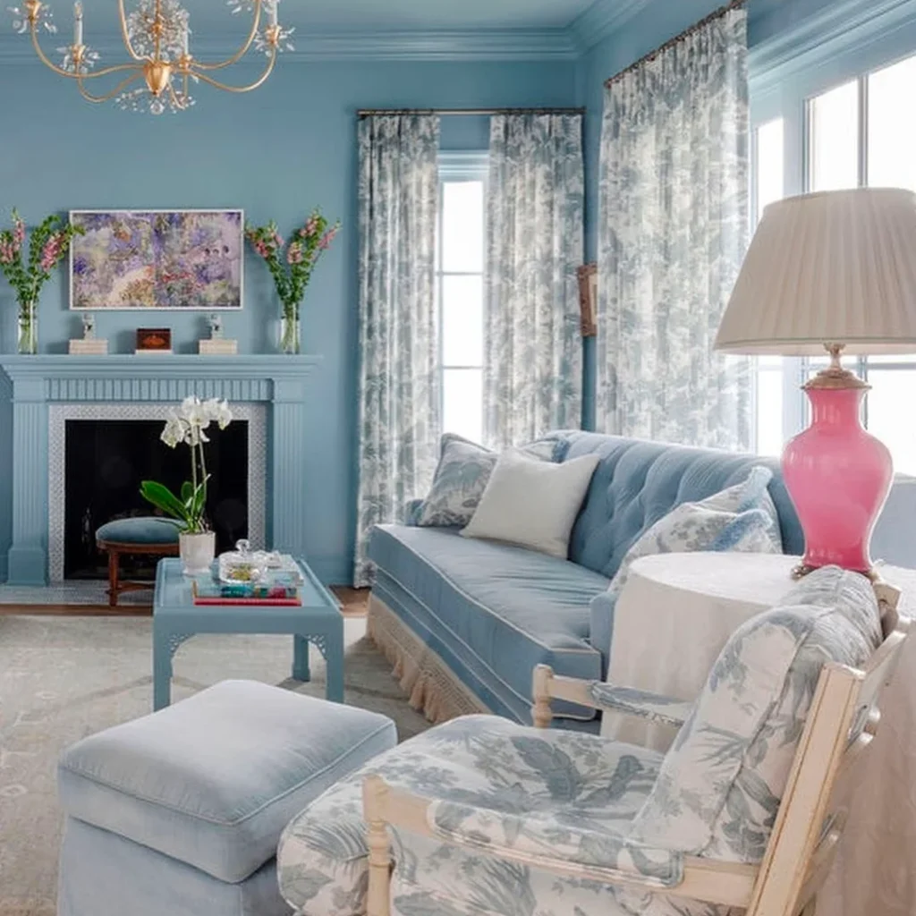 An all-grey granny chic living room looks inviting and cozy. On the round side table is a pink lamp.