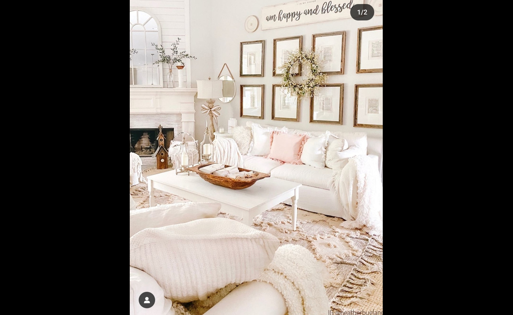 Farmhouse chic living room with white overstuffed seating and raised rug on floor.