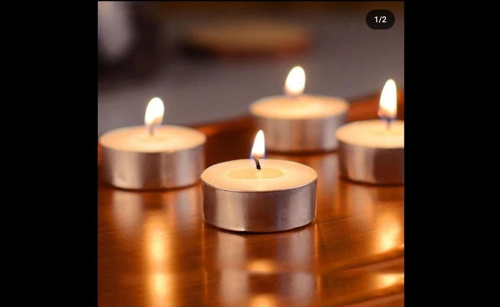 4 lighted tea light bronze candles placed on wooden table.