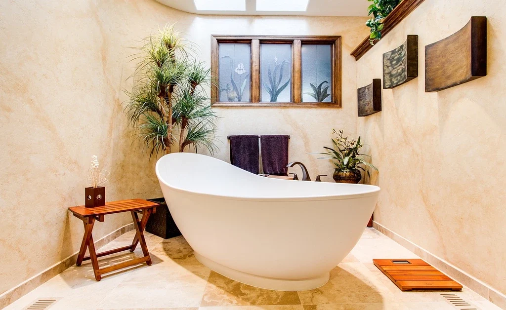 A large freestanding white bath tub in middle of bathroom.