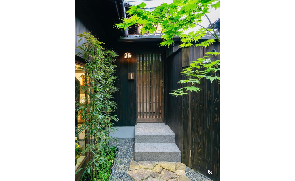 the entrance of a Japanese-style living room surrounded by natural greenery.