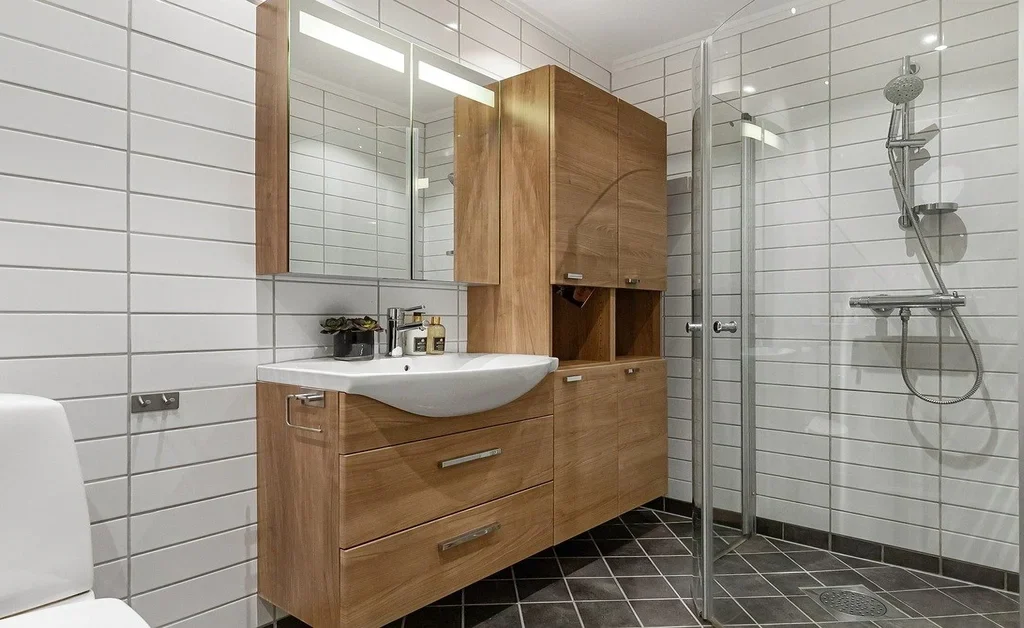 A white themed japandi bathroom with perfect wooden storage.