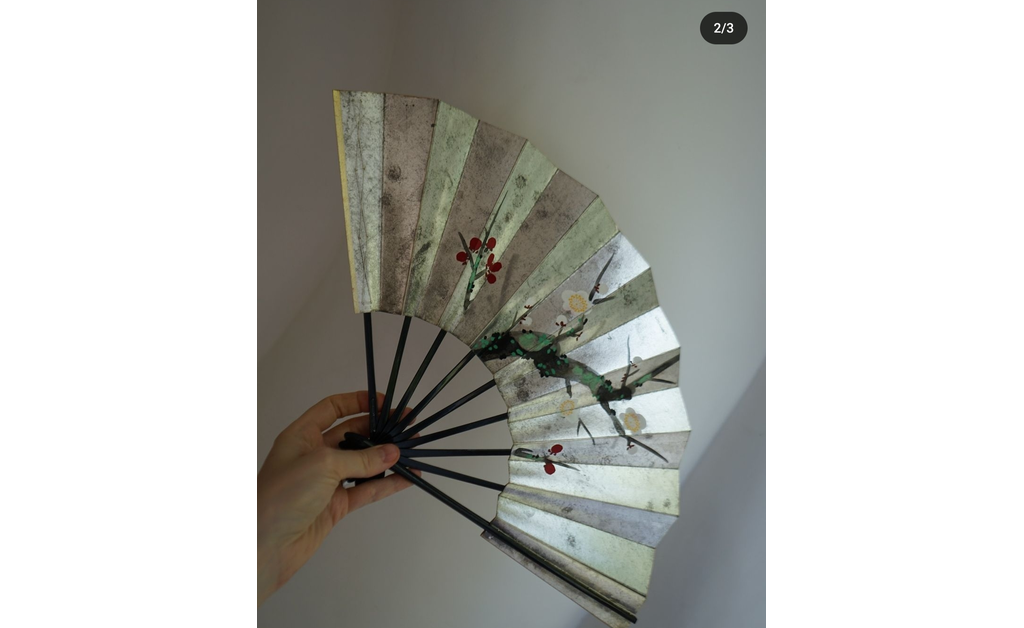 A hand, holding traditional Japanese hand fan (sensu).